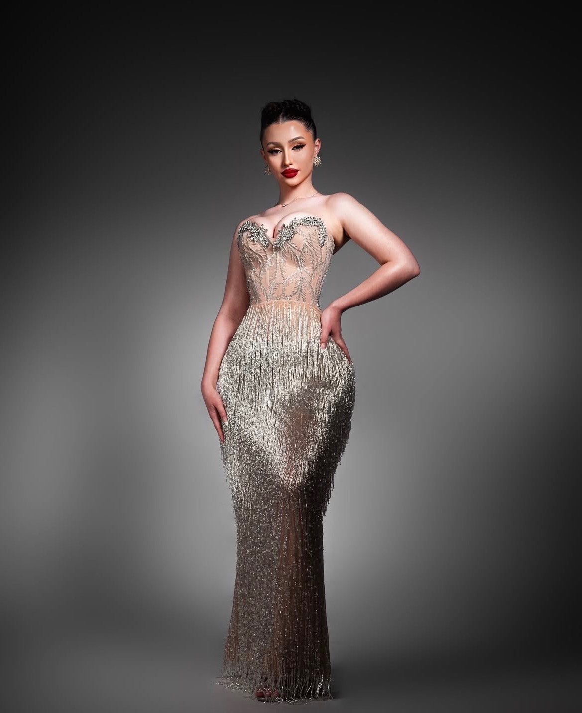 Black and white editorial portrait of a model in a silver embellished gown